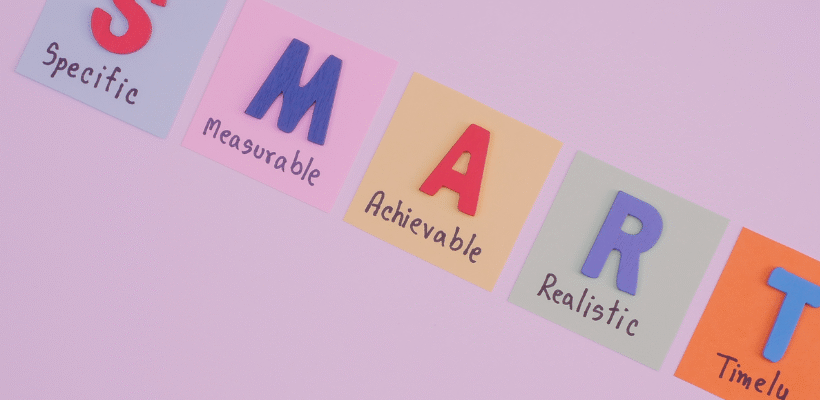 Na obrazku widać notes z kolorowym napisem "SMART"